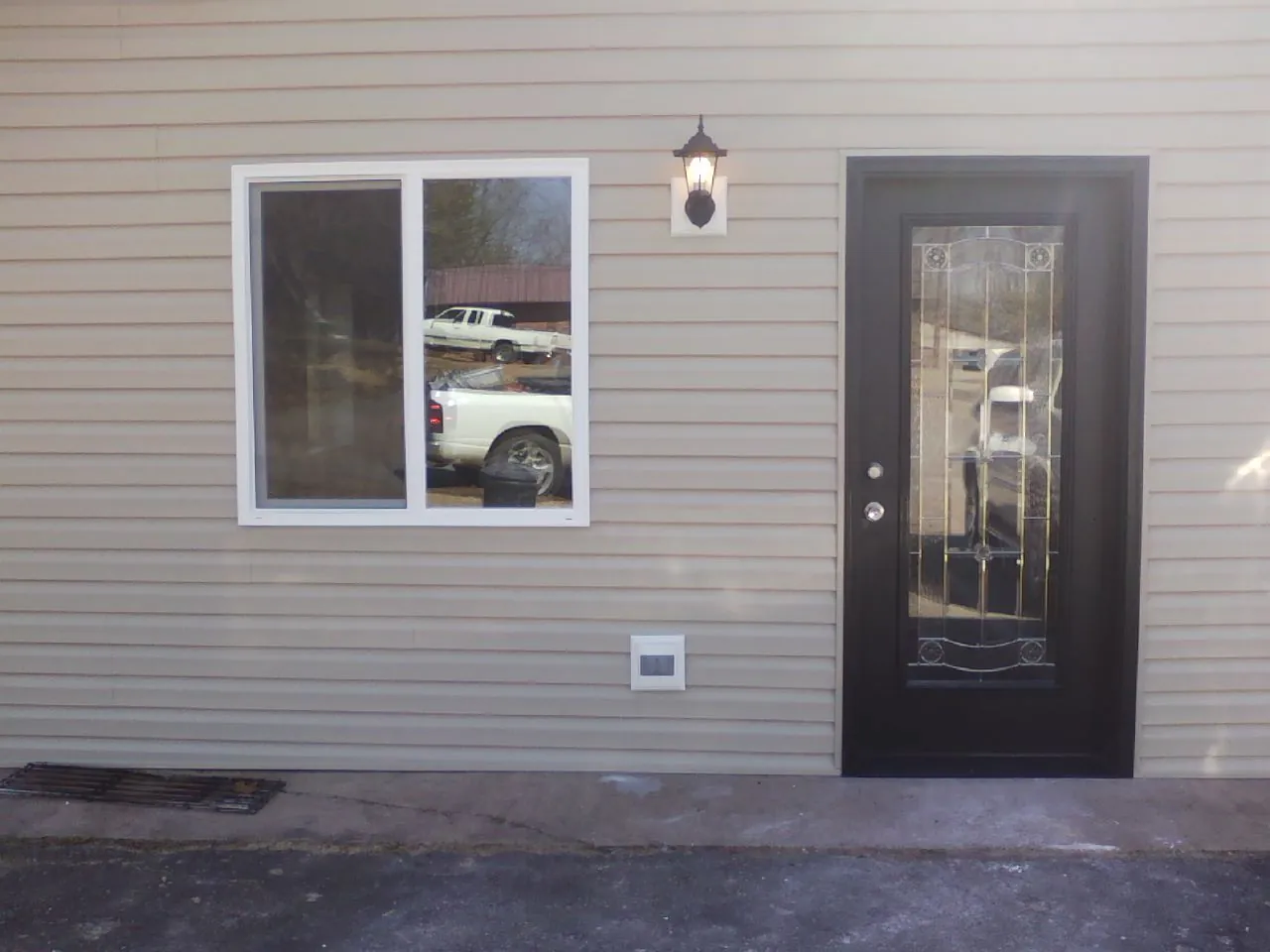 New siding, window and entry door on the side of an addition in Covington